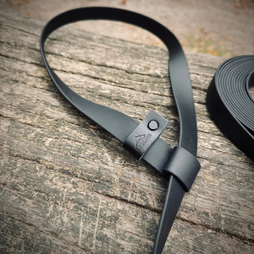 Black Biothane dog lead loop resting on wooden surface, premium handmade leash material