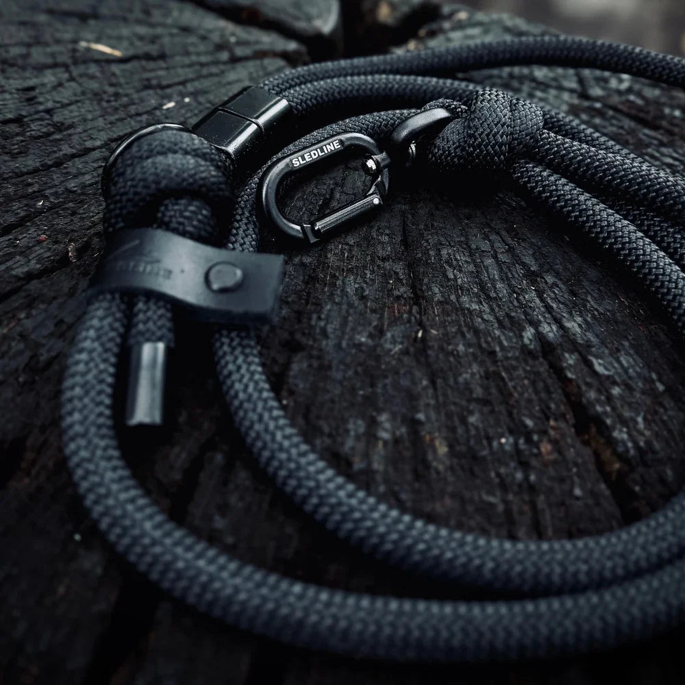 Black rPET rope dog lead with Biothane accents and metal hardware on wood surface