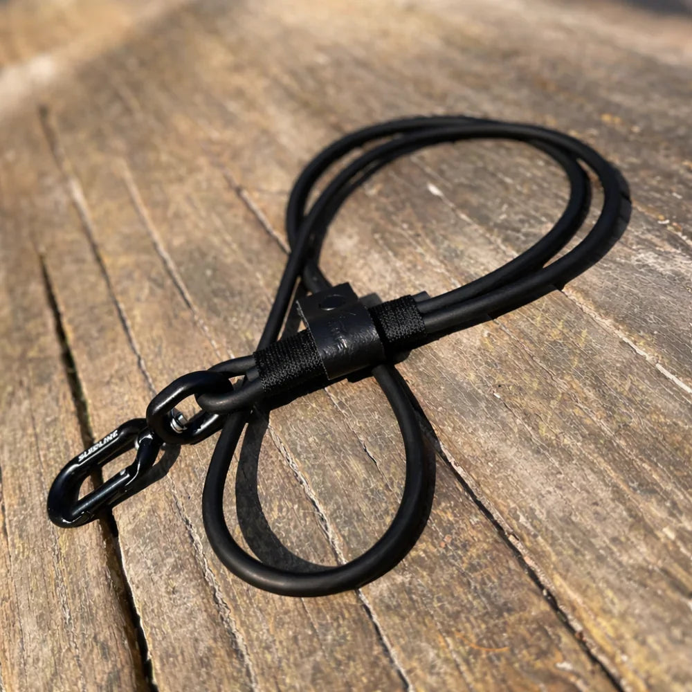 Black rPET rope and Biothane dog lead with metal hardware on a wooden surface