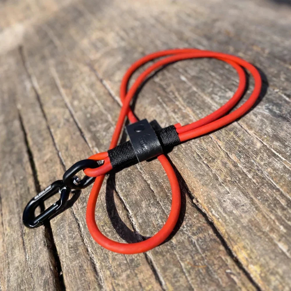 Red rPET rope dog lead with black Biothane and metal clip on wooden surface