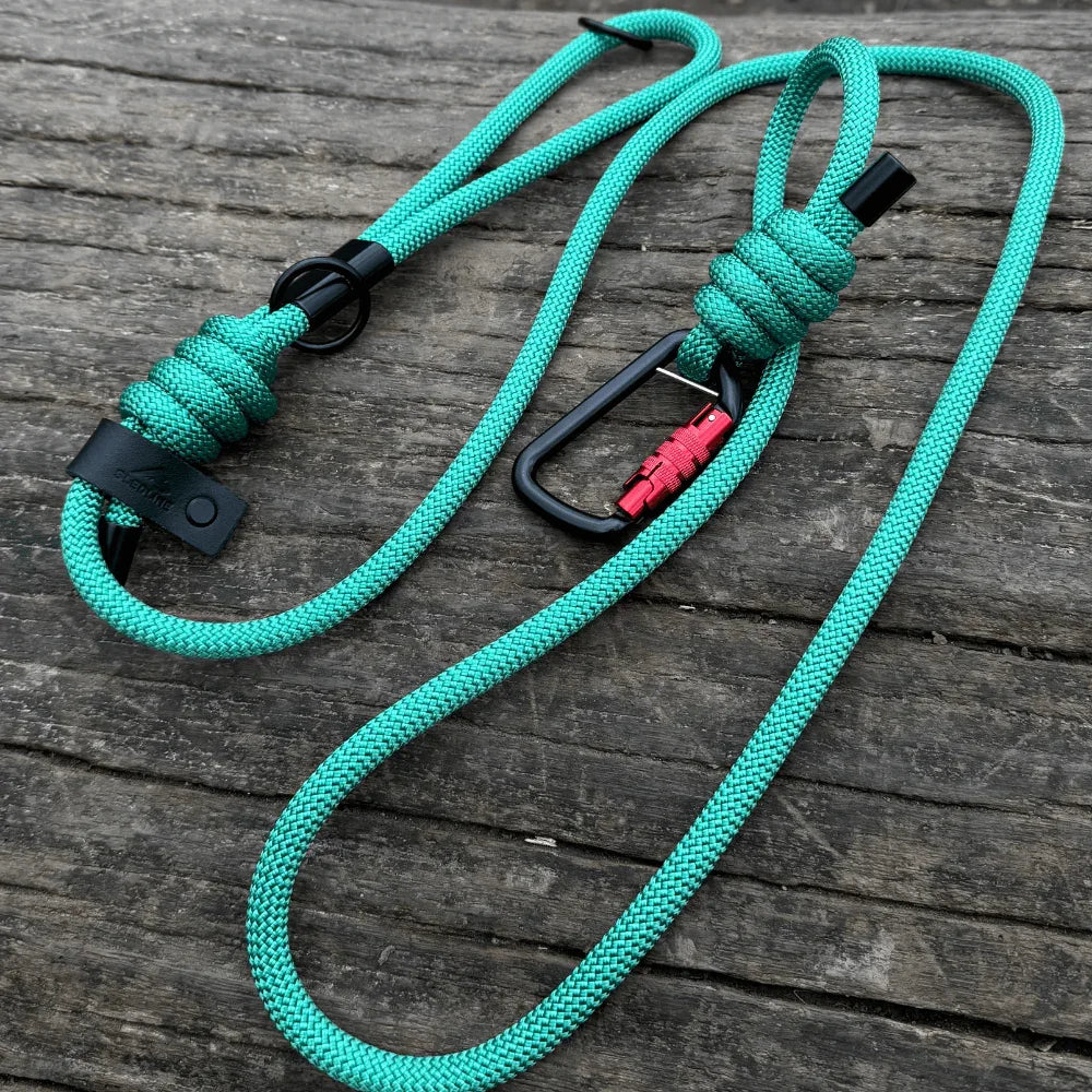 Green rPET rope dog lead with Biothane accents and metal hardware on wood surface