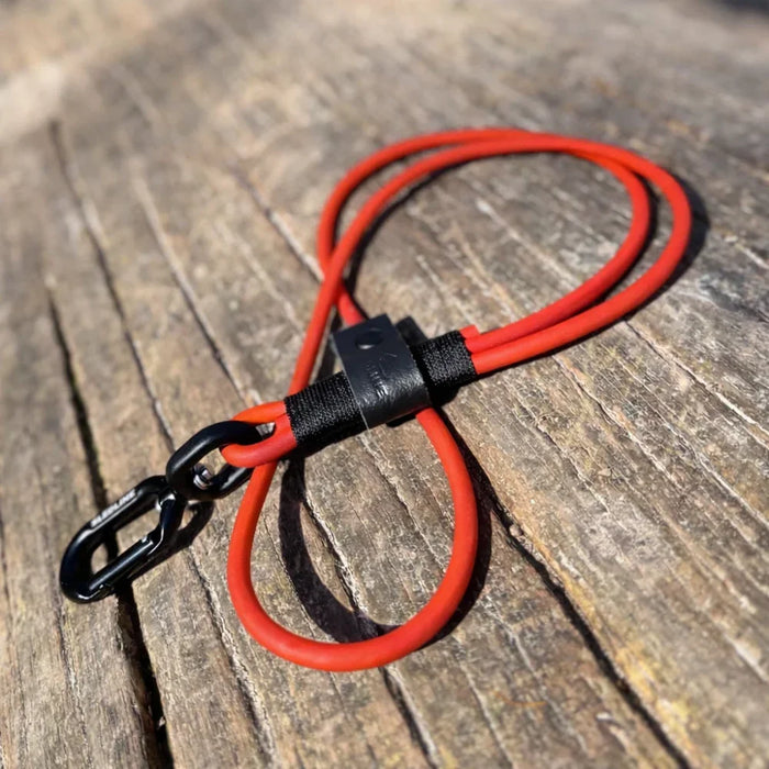 Red rPET rope dog lead with black Biothane and metal clip on wooden surface