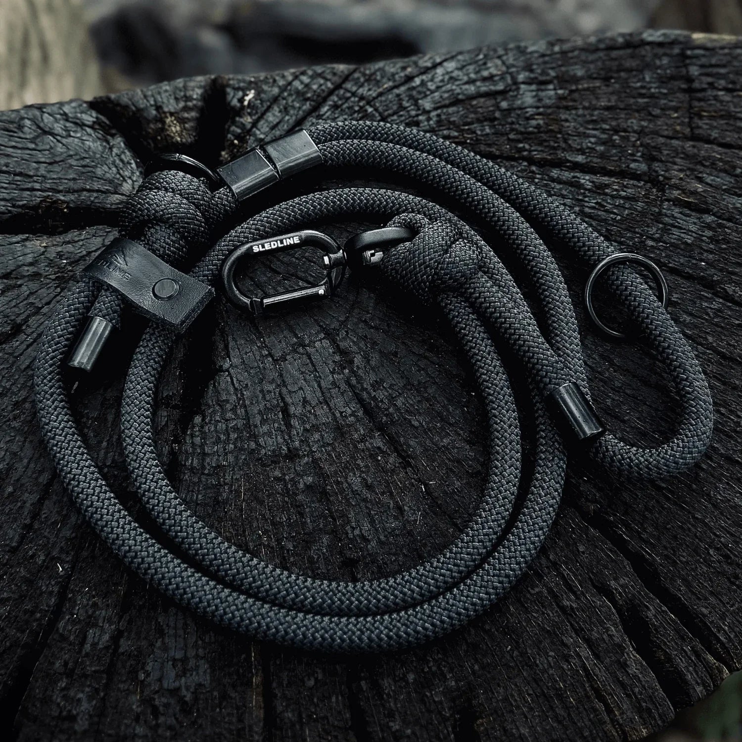 Black rPET rope dog lead with metal hardware displayed on rustic wood surface